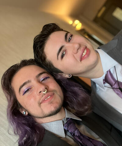 Reuven and Dmitri dressed in suits with lavender ties, nails, and makeup a là the wedding colors of Tyler Flood and Katie LaBelle!